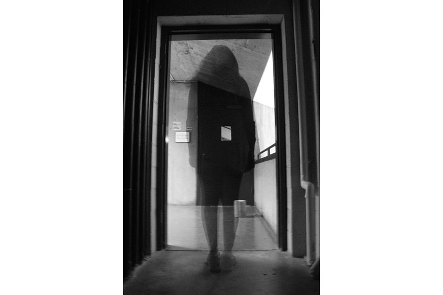 Black and white photograph: silhouette in doorway