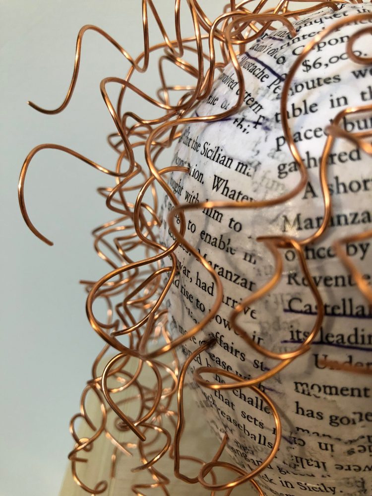 Papier-mache, close-up of curled pieces of copper wire used as hair