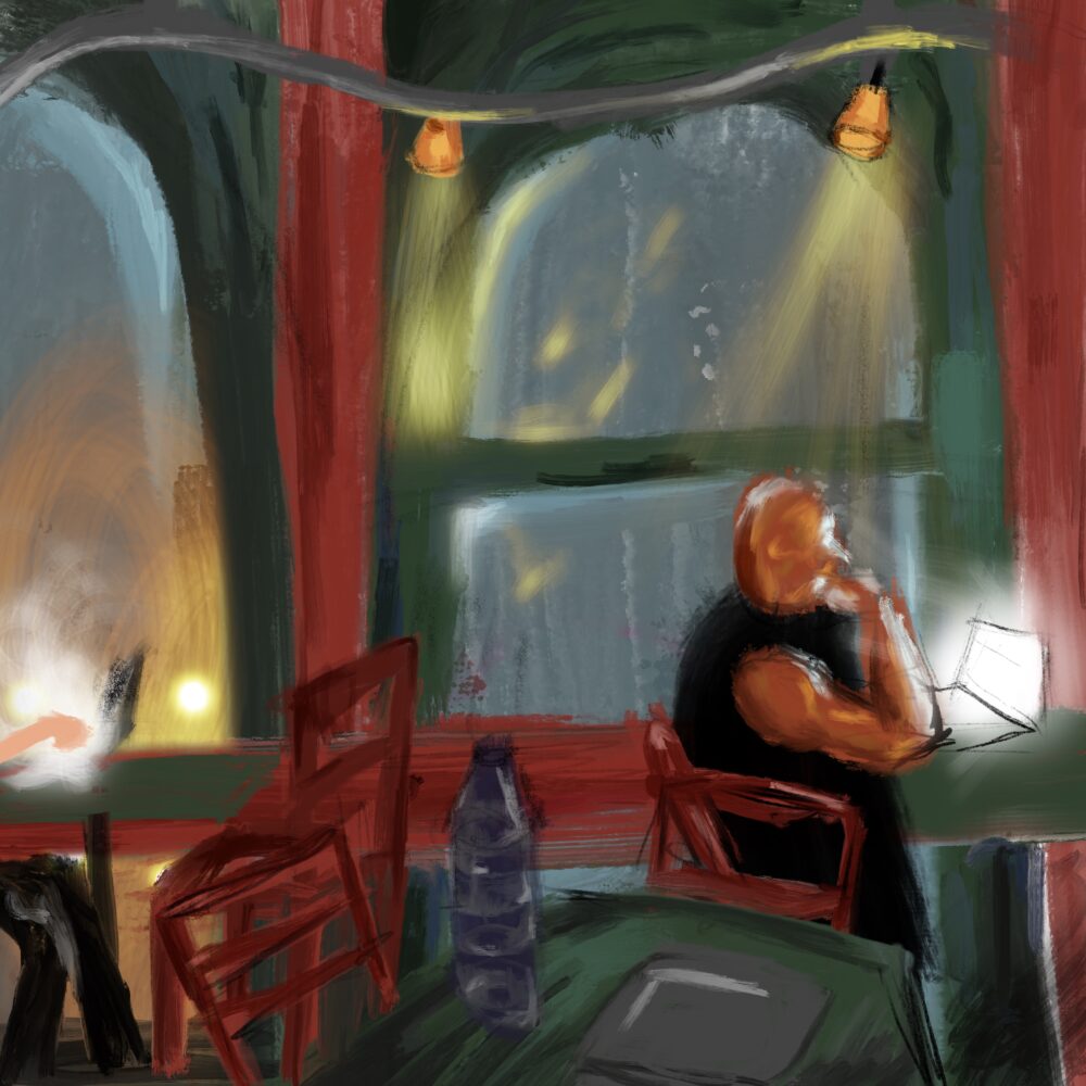 The cafe interior at night, a patron works on a laptop by the window