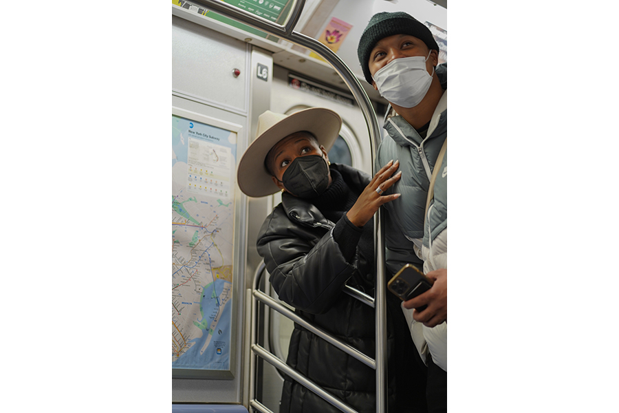 A couple holding a subway pole