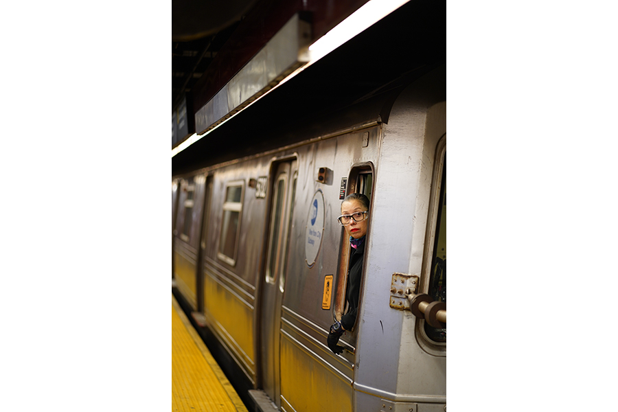 A female conductor leaning out the subway window