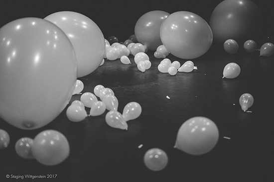 White balloons of various sizes on the ground. 