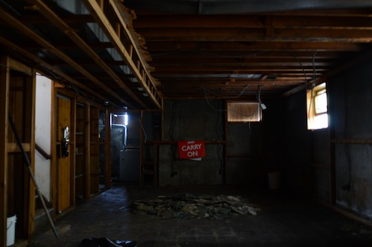 The dark, emptied-out floor of a home, with some light coming in through upper windows.