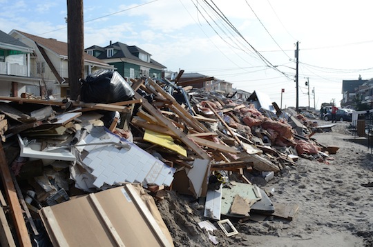 Piles of wreckage, lined up in front of homes. 