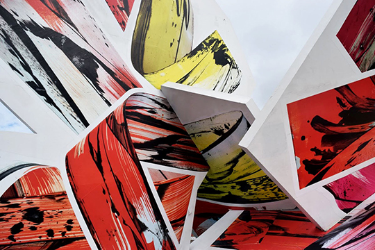 Photograph, closeup, of abstract art, twisted forms show streaks of yellow, black, and red ink