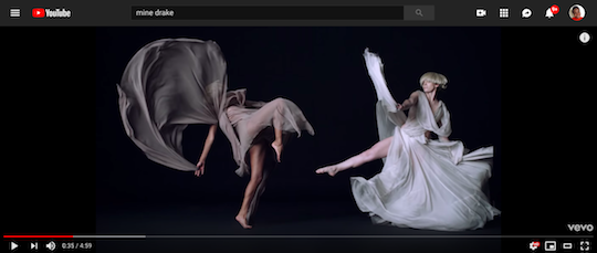 A screengrab from "Mine," by Beyonce, a music video featuring dancers wearing etherial beige, gray and mauve gowns sway and jump in slow motion.