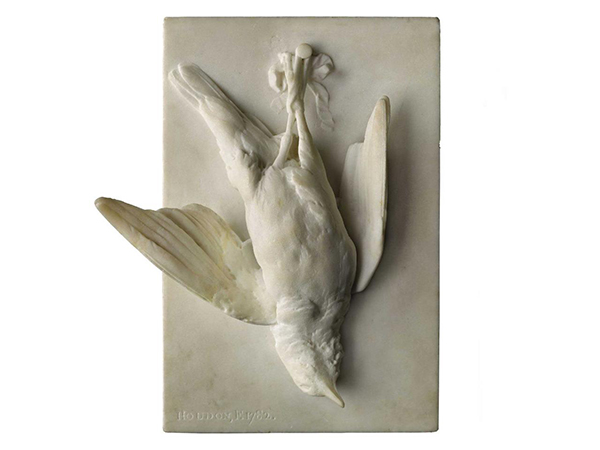 A dying bird carved out of white marble, pinned on a white marble background.