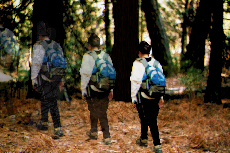 A young man walks into the woods wearing a backpack, digitally altered to appear like four men walking in a row. 