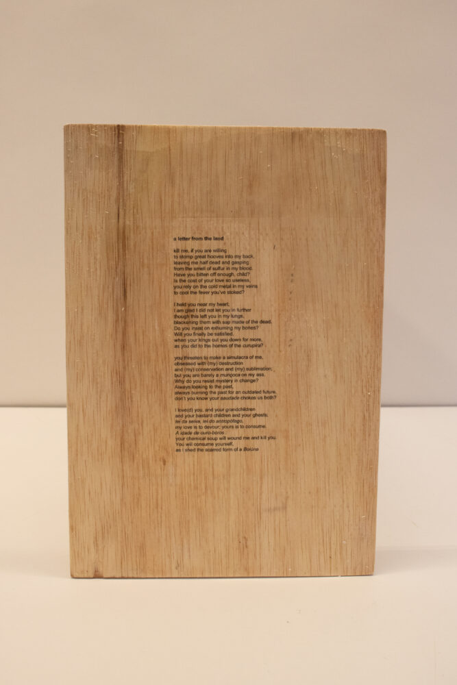 Wood panel with the author's "A Letter from the Land" printed on with black ink. 