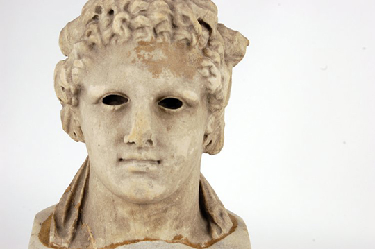 Marble head of Dionysos wearing ivy wreath, eyes hollowed for inlay