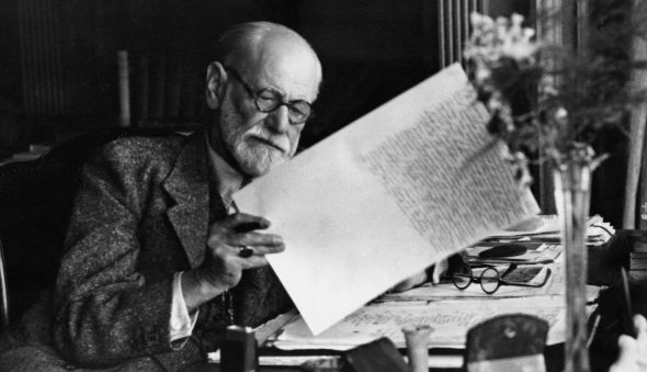 Sigmund Freud reading at his desk.