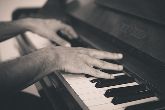 Hands playing piano.