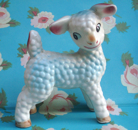 White porcelain lamb against bright blue floral wallpaper. 