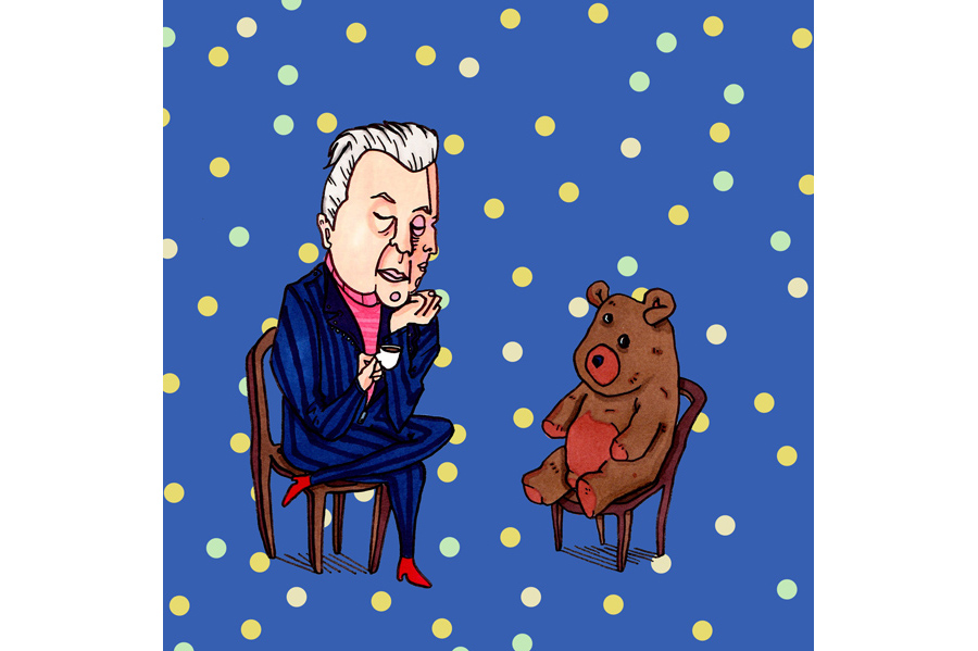 A two-faced man sitting on a chair facing a teddy bear sitting in a chair against a blue background with pink, blue and purple polka dots. 