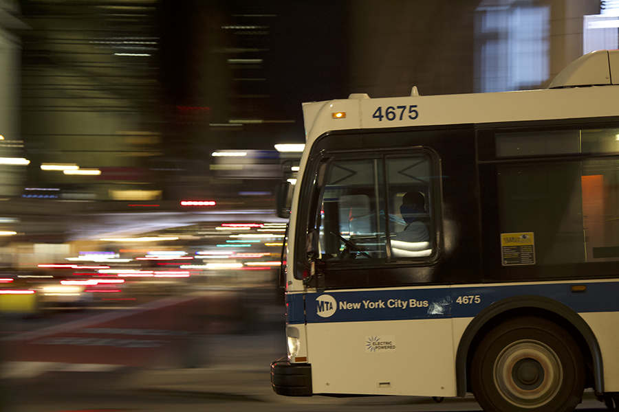 A bus in motion, as seen from a sidewalk on 42nd Street.
