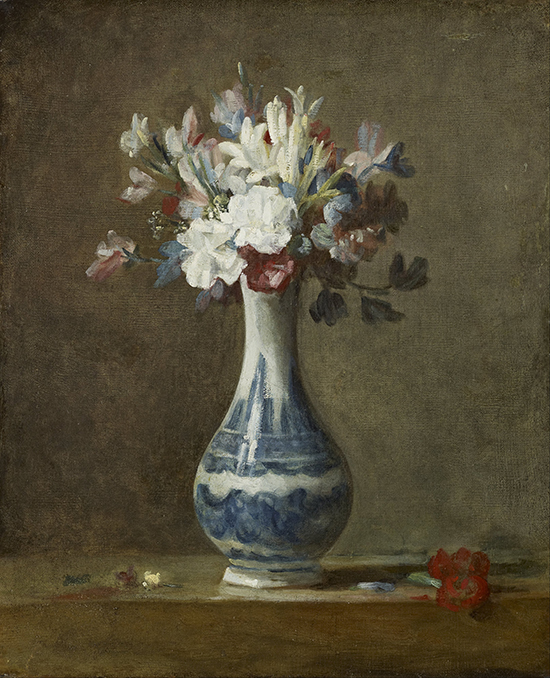 A vase of assorted flowers in a blue and white vase on a deep olive background. 