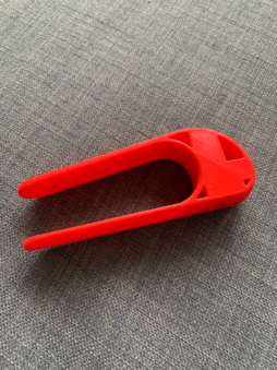 A red plastic U-shaped writing tool