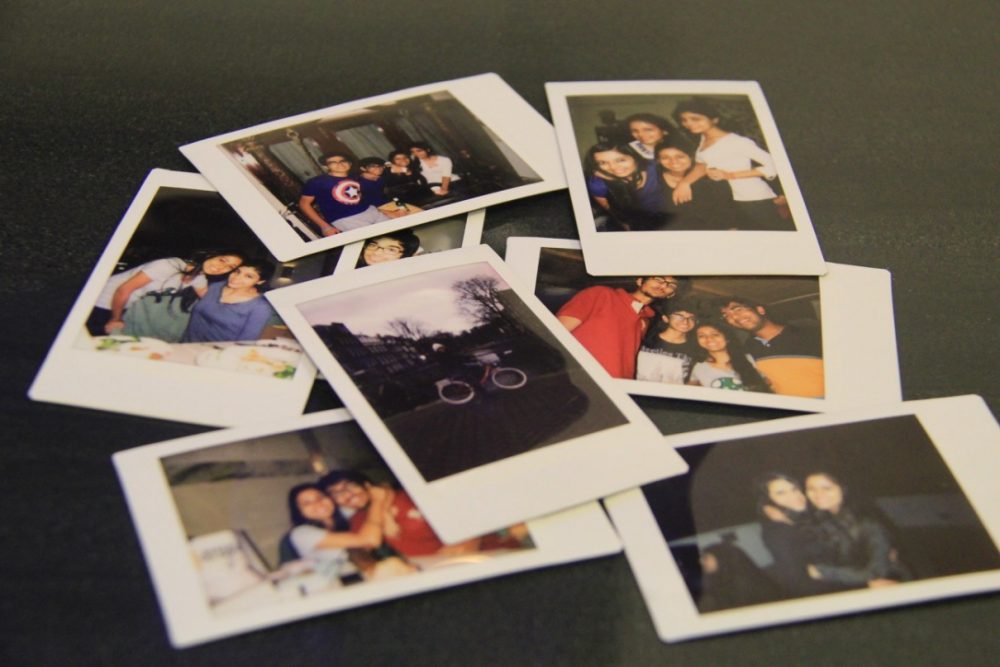 A 8 group of Polaroid pictures, spread out on a table. 