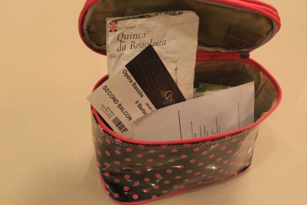 A small, open bag with papers, tickets, and a map emerging.