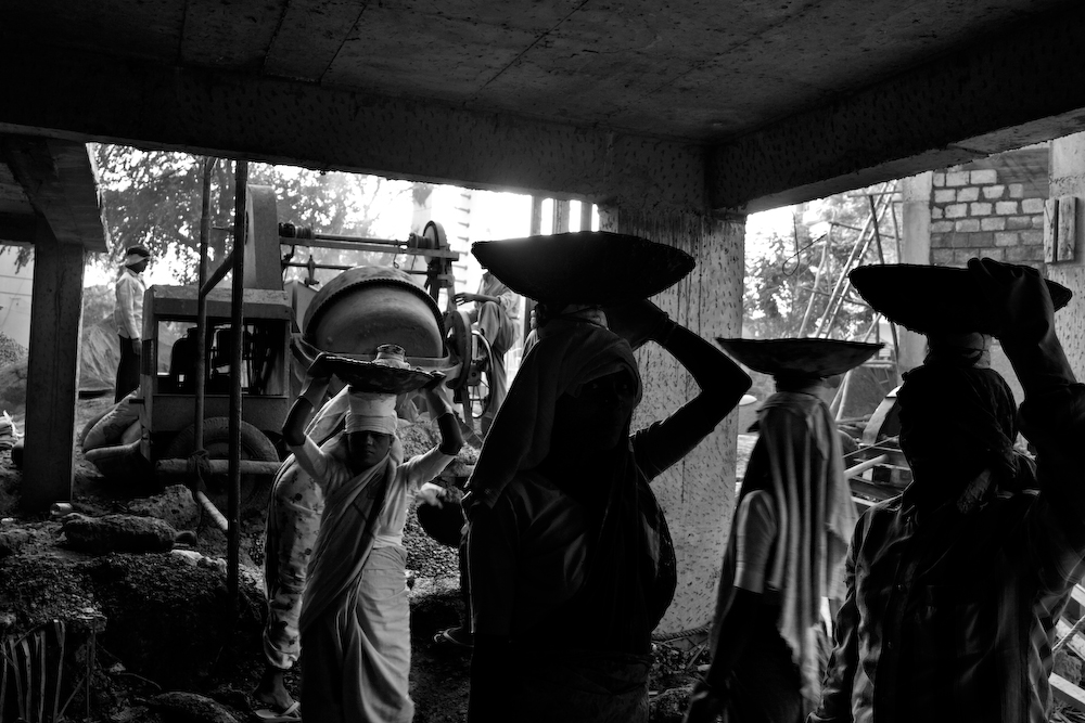 Women holding woven baskets on their heads (in black and white).
