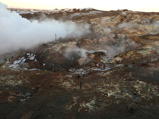 A photograph of steaming volcanic rock