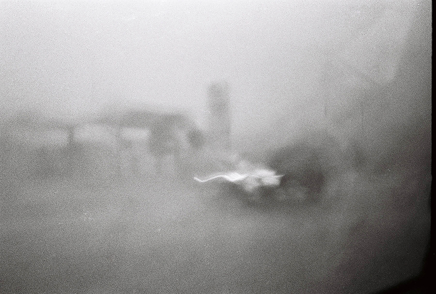 blurred grey photo, with some structures barely visible in the background