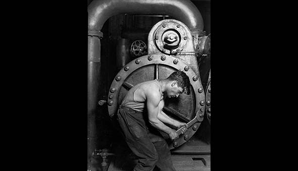 A power house mechanic tends to a machine