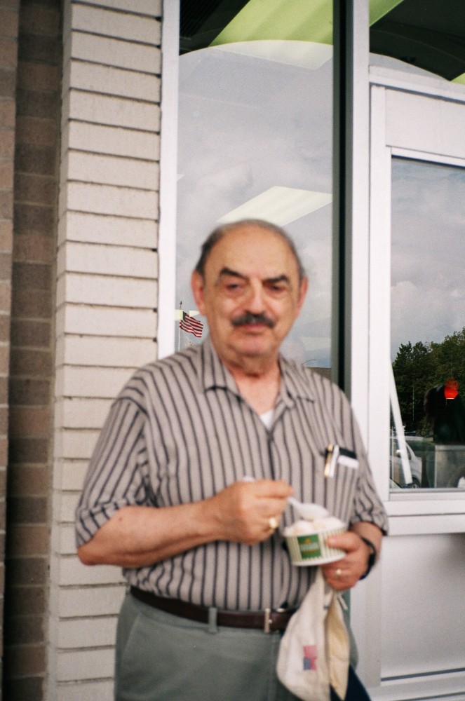A man eating ice cream with two small American flags visible in the frame. 