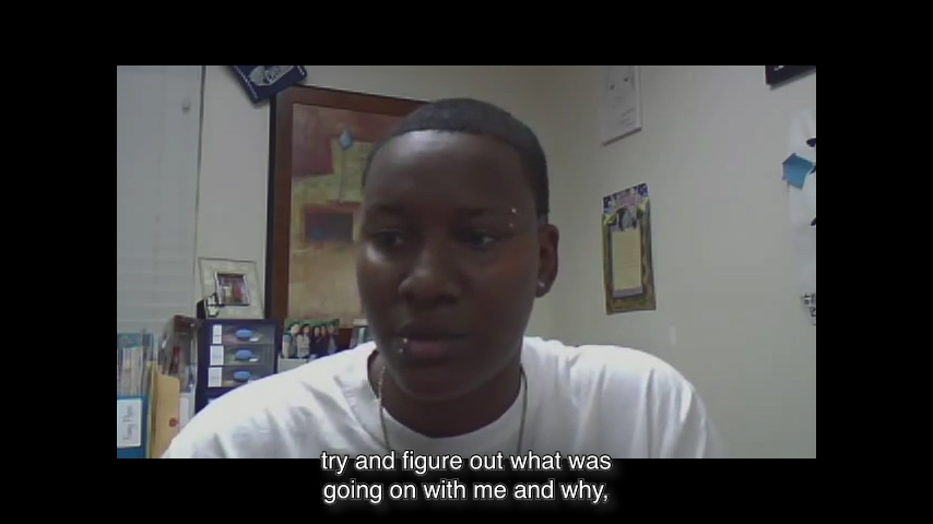 Webcam still image of a boy facing the camera. Subtitles: “...try and figure out what was going on with me and why…”
